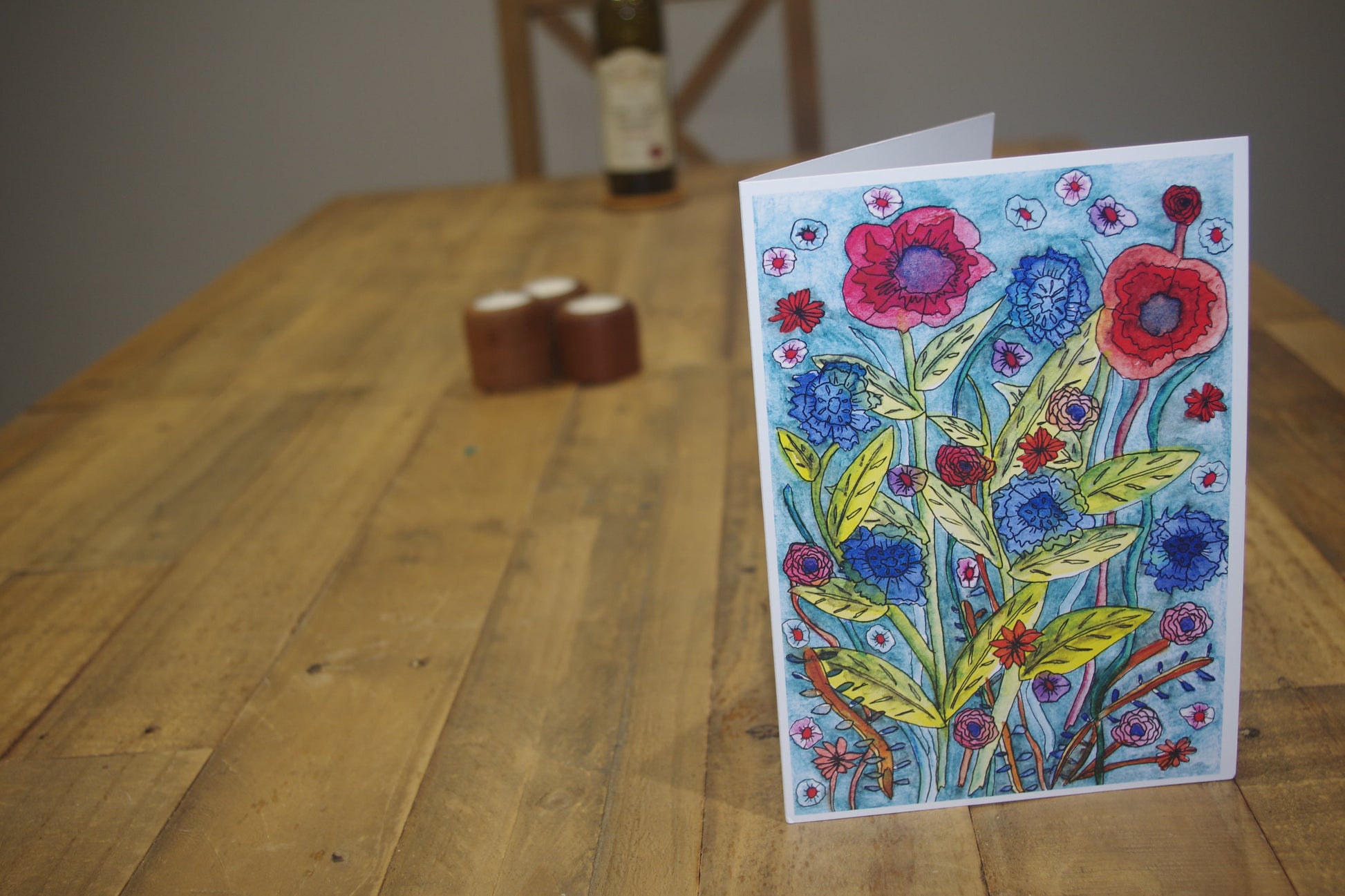 Brighten someone's day with this beautiful card. The self-seeded mix of vibrant red poppies coupled with the calming blues of the wild cornflowers.